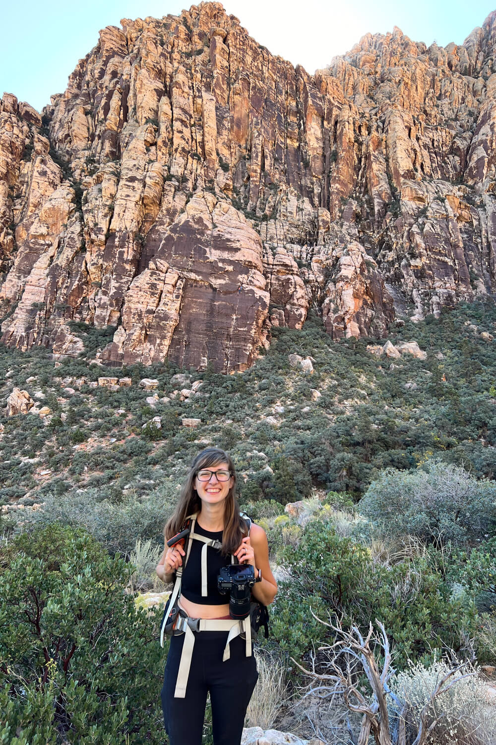 standing in front of a giant rock on the icebox canyon trail in red rock canyon