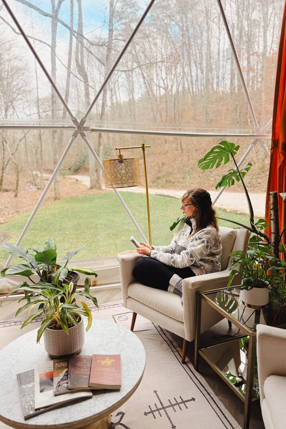 girl reading kindle inside glamping dome in madisonville tennessee in the winter